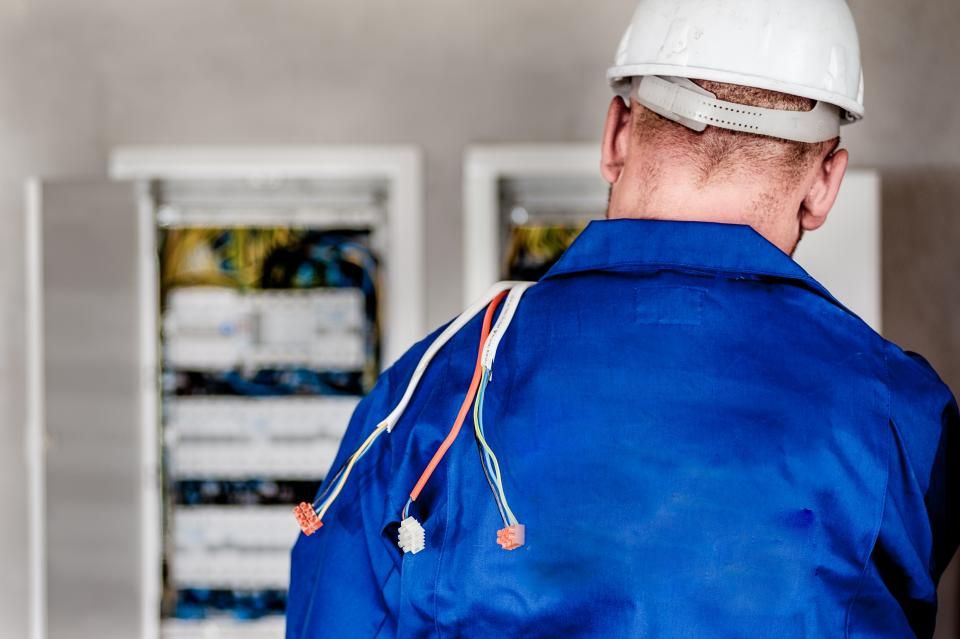 Electricista trabajando frente a un tablero eléctrico